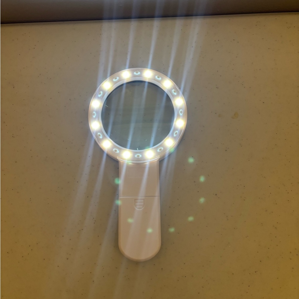 Lighted magnifier for reading hand held, white.
